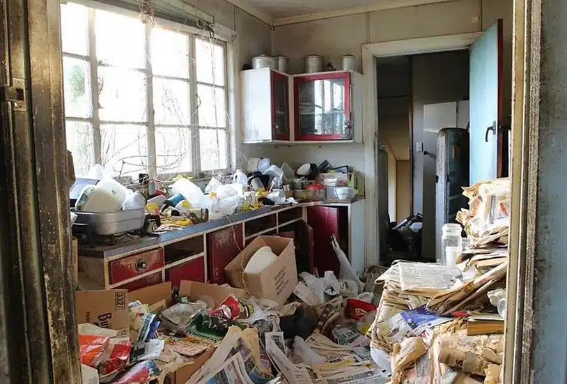 A kitchen with a lot of trash and junk in it